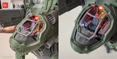 A detailed 3D-printed mech cockpit with illuminated interior controls and seat.