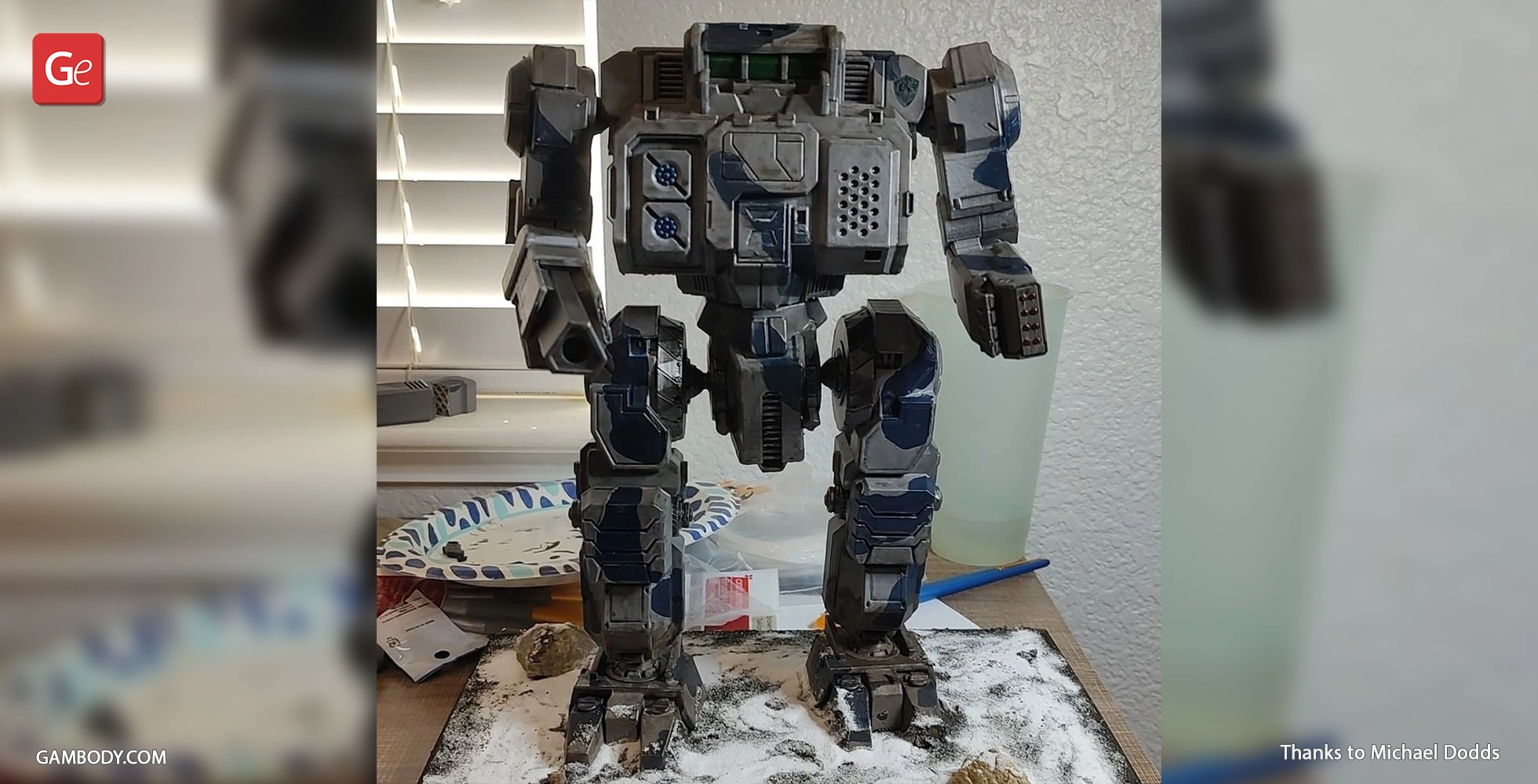 A detailed 3D-printed MWO Highlander mech model, painted and displayed on a textured base.
