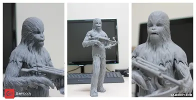 3D-printed model of a tall, hairy creature holding a weapon. Figure displayed on a table.