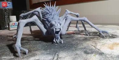 A spiky creature with long, thin legs and a menacing grin on a textured surface.