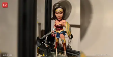 Chibi Wonder Woman 3D print model, with sword and shield, displayed on a 3D printer platform.