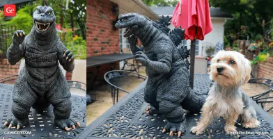 A detailed Godzilla model in a garden setting, next to a small dog on a metal table.