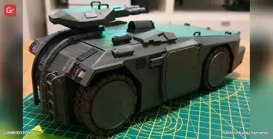 Detailed 3D-printed model of an armored personnel carrier, shown on a cutting mat.