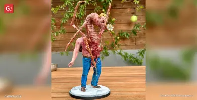 A monstrous creature with spider-like legs emerging from a human torso on a display base.