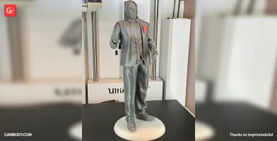 A 3D printed statue of a man in a suit, standing and making a gesture.