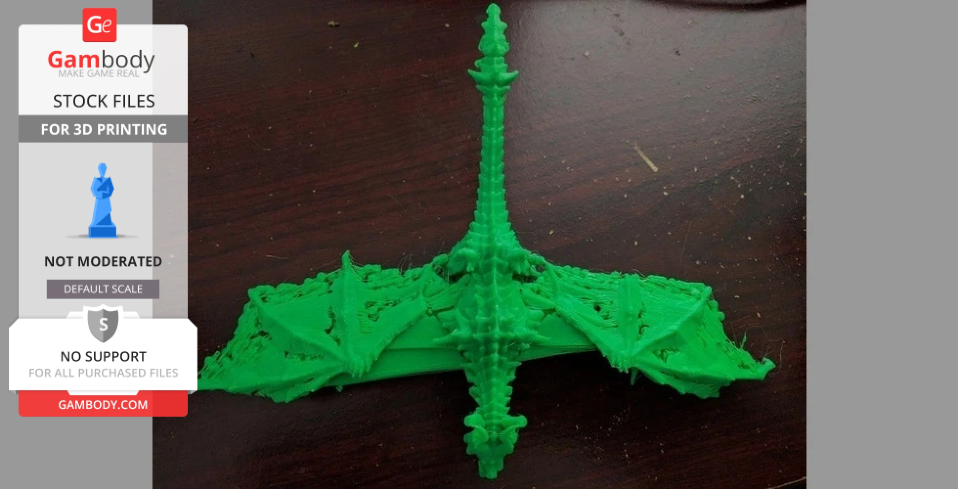 A green 3D-printed dragon model with detailed wings and spine, viewed from above on a wooden surface.