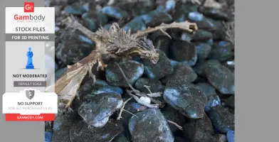 A detailed miniature dragon model with outstretched wings on textured stones.