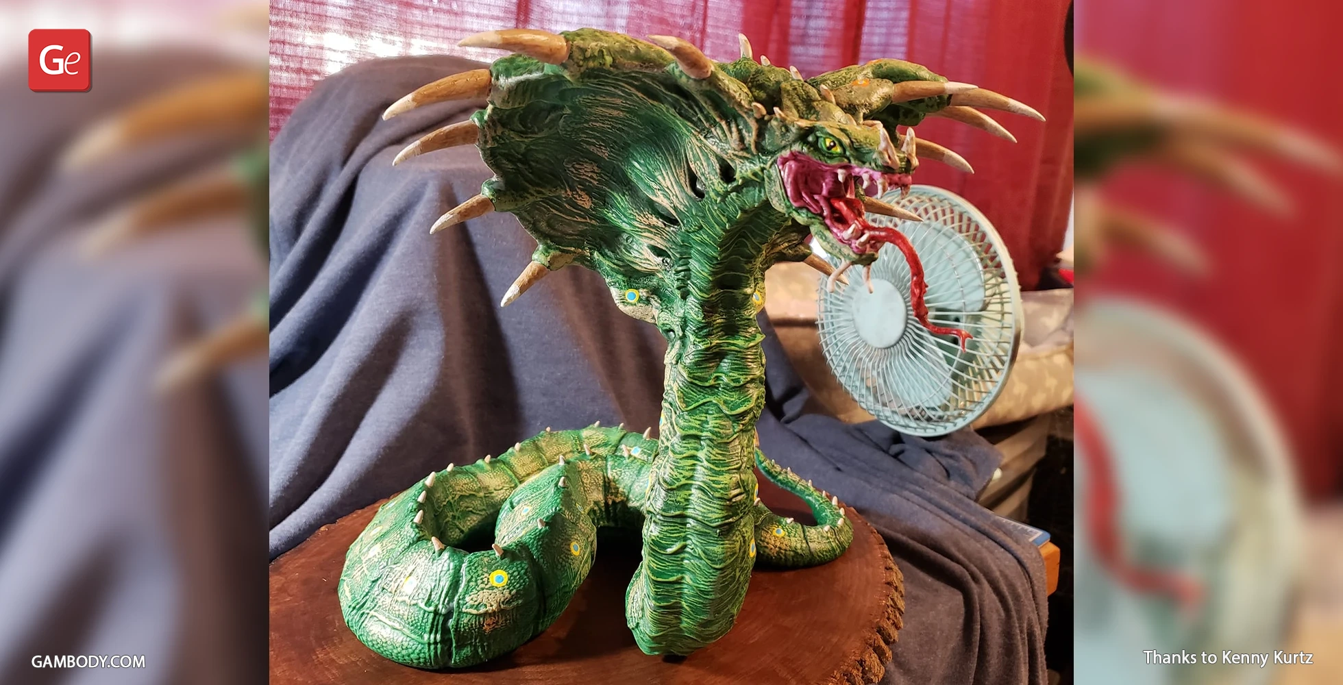 A detailed green King Cobra 3D model with a hood and fangs displayed on a wooden base.