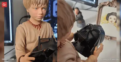 A 3D printed model of a young boy holding a detailed mask, with a framed photo and small busts behind him.