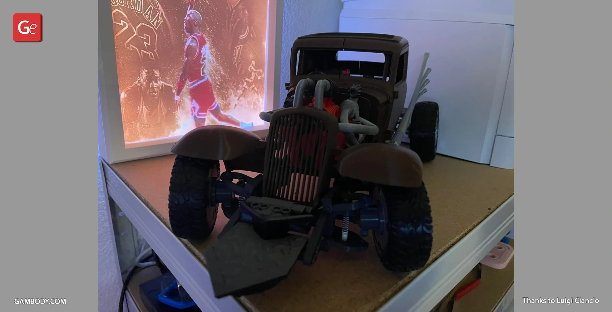 3D-printed model of a rugged, apocalyptic-style car with exposed engines and pipes on a display shelf.