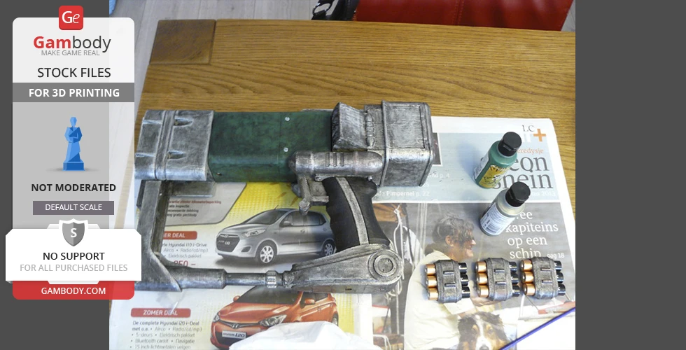 3D printed Fallout laser pistol on a table with paint bottles and battery packs.