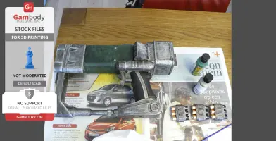 3D printed Fallout laser pistol on a table with paint bottles and battery packs.