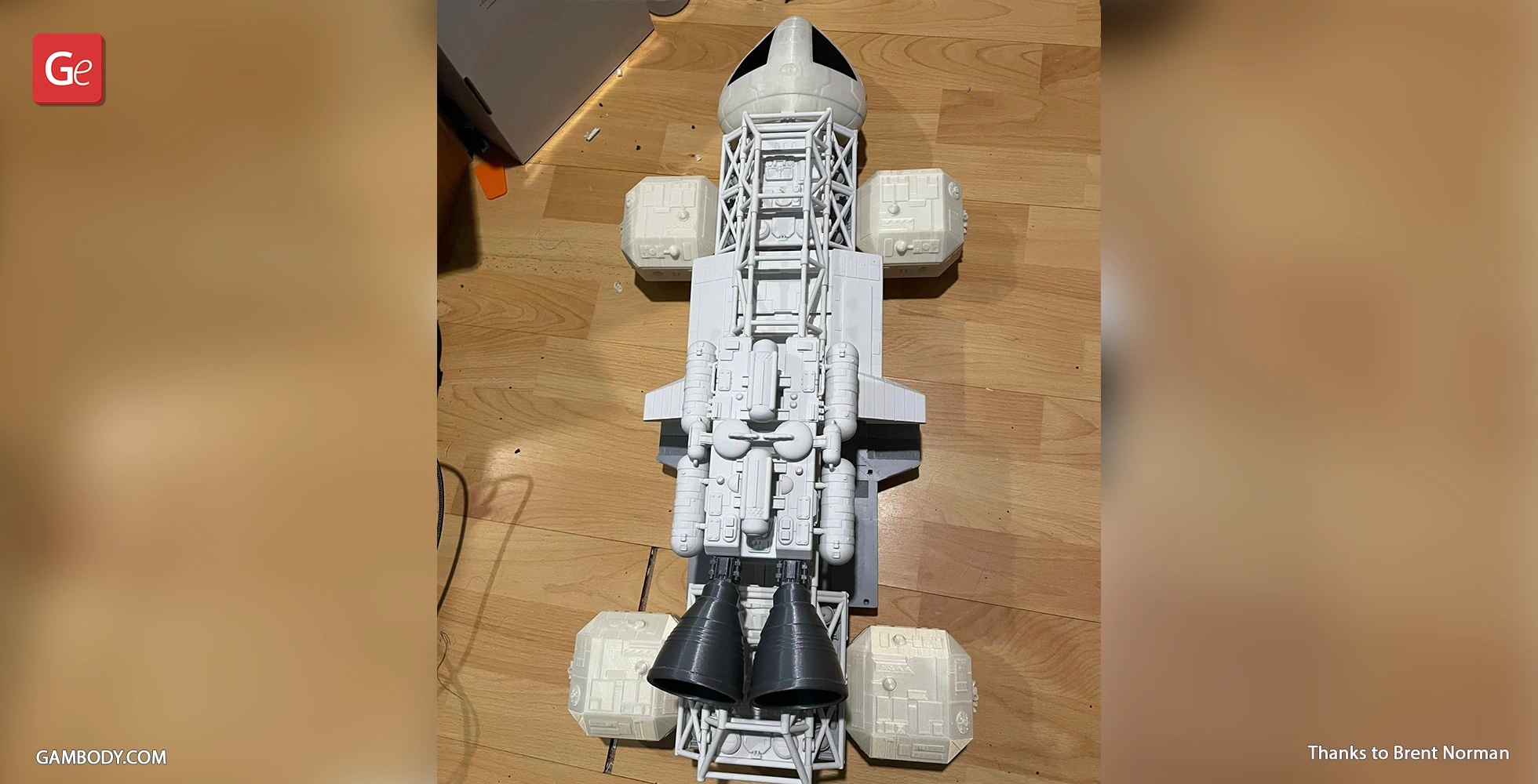 A detailed 3D-printed model of an Eagle Transporter spaceship on a wooden floor.