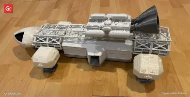 A detailed 3D printed model of an Eagle Transporter spacecraft on a wooden surface.