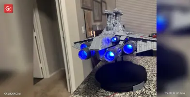 Venator-class Star Destroyer model with illuminated blue thrusters on a display stand.