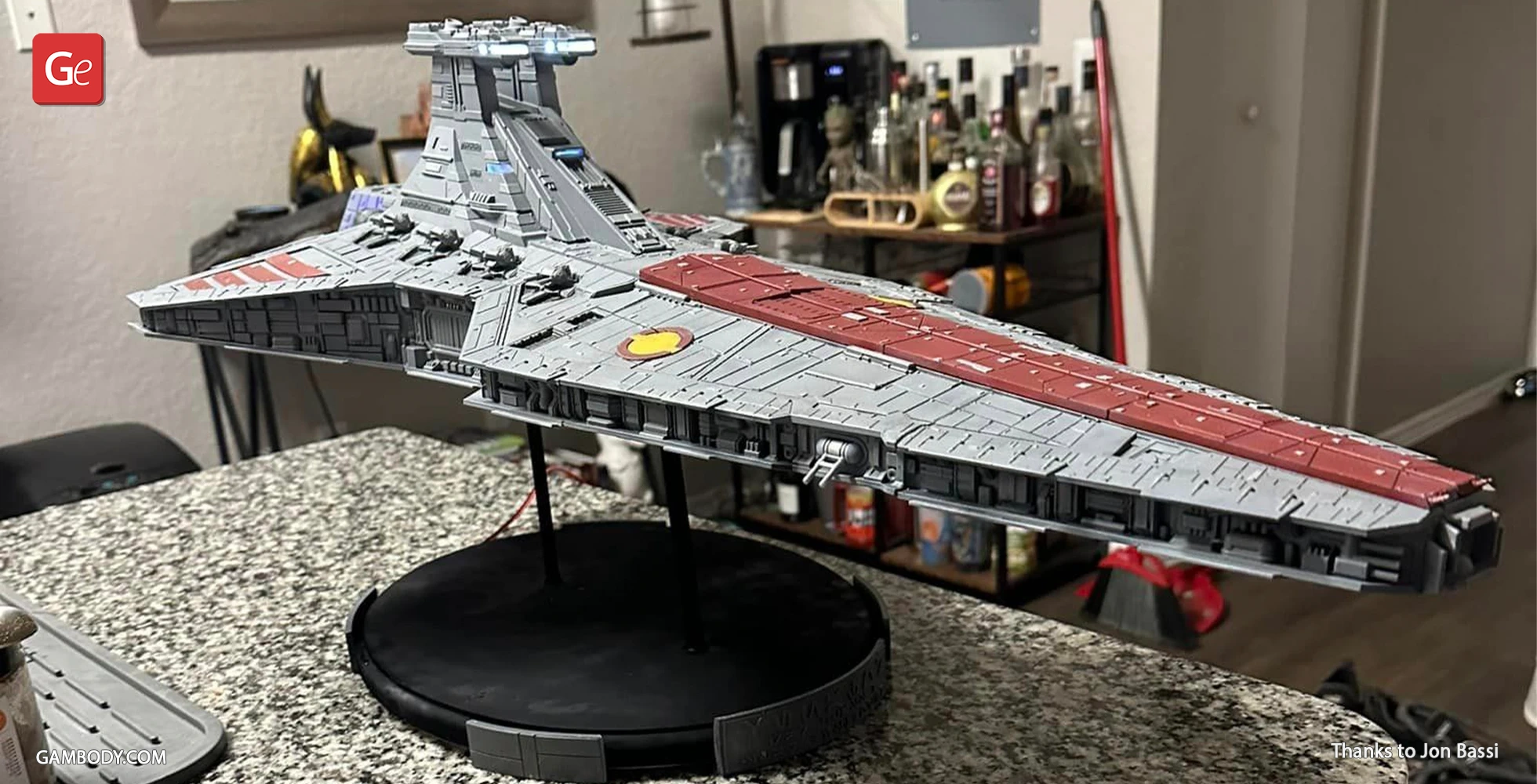 A detailed 3D printed model of a Venator-class Star Destroyer displayed on a stand indoors.
