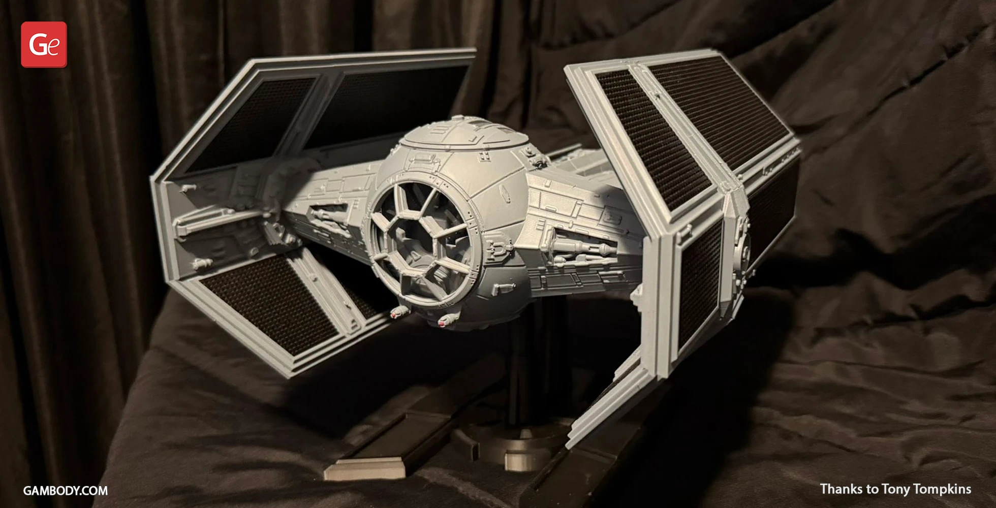 3D-printed TIE Advanced model from Star Wars, displayed on a stand with detailed panels and wings.