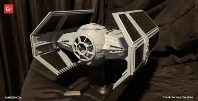 3D-printed TIE Advanced model from Star Wars, displayed on a stand with detailed panels and wings.