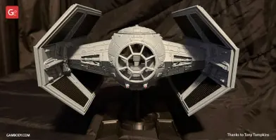 A detailed 3D model of the TIE Advanced spaceship for 3D printing, displayed on a stand.