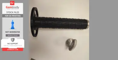 Black textured sword handle and small decorative metallic piece on a white surface.