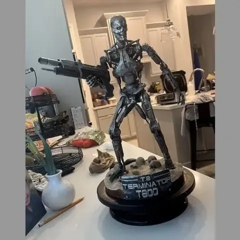 A detailed T-800 Terminator endoskeleton model holding a gun on a base labeled 'The Terminator T-800.'