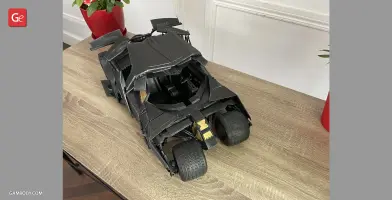 A detailed 3D-printed model of the Tumbler vehicle from the Dark Knight series on a wooden table.