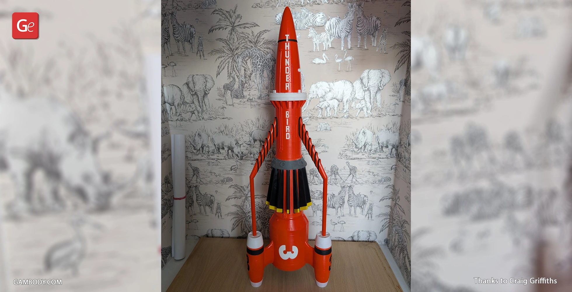 Red and white rocket model labeled 'Thunderbird 3,' displayed against a safari-themed wallpaper.