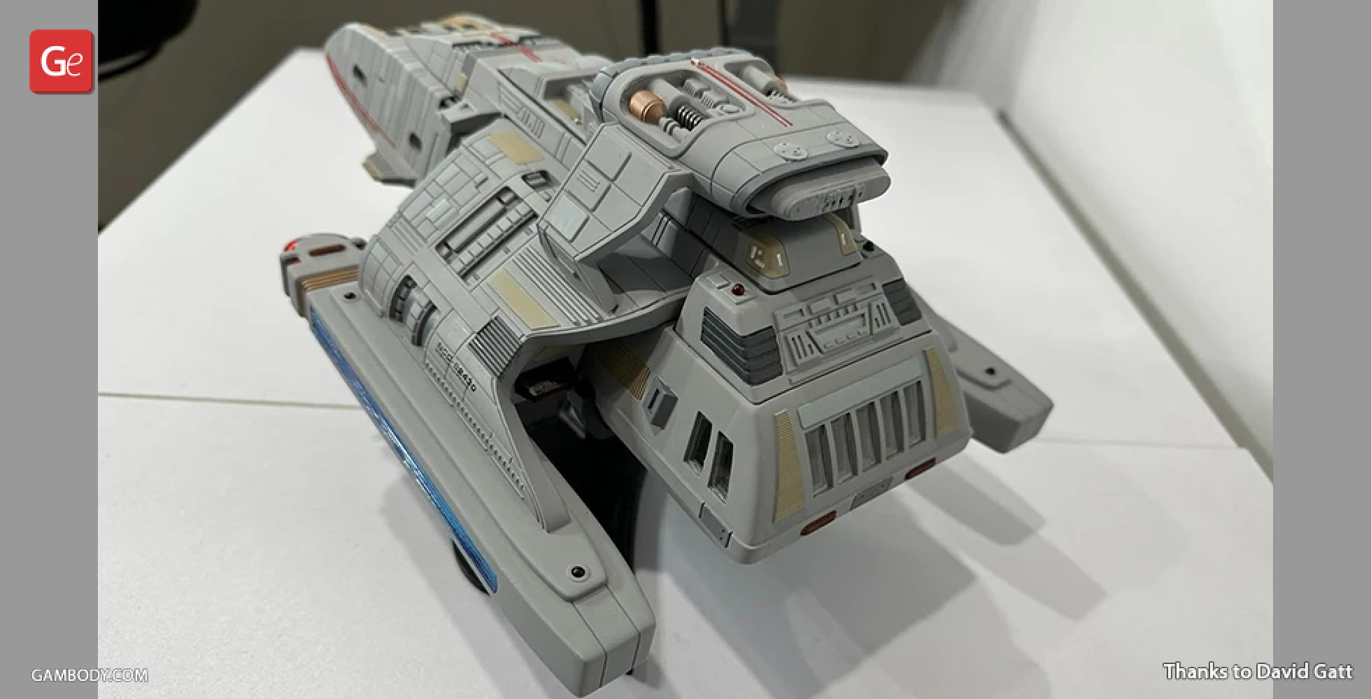 A detailed 3D printed model of a futuristic spacecraft, gray with intricate surface features and blue accents.