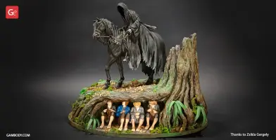 A Nazgul on horseback above four hidden Hobbits under a tree in a detailed diorama.