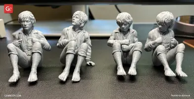 Four seated hobbit figurines in detailed poses, crafted for 3D printing, on a tabletop.