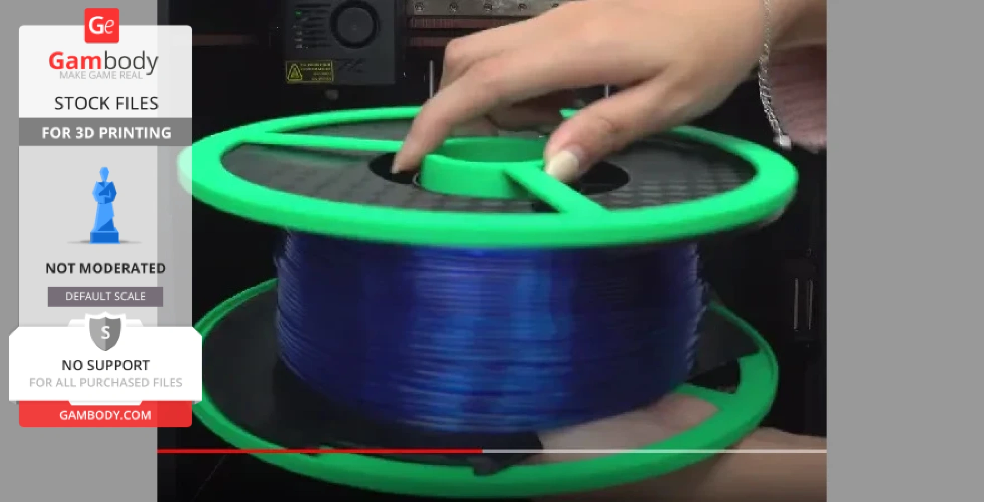A green filament spool with blue filament, held by a hand, for 3D printing.
