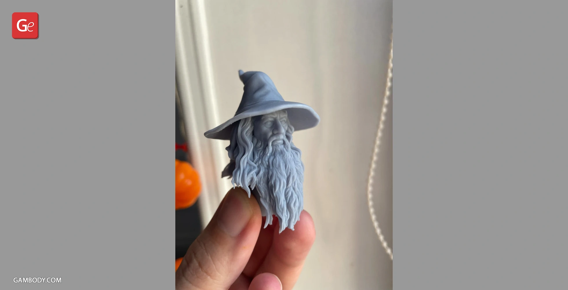 3D-printed bust of a bearded figure in a wide-brimmed hat, held in a hand.