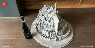 A detailed 3D-printed model of Minas Tirith from LOTR, next to a wine bottle for scale.