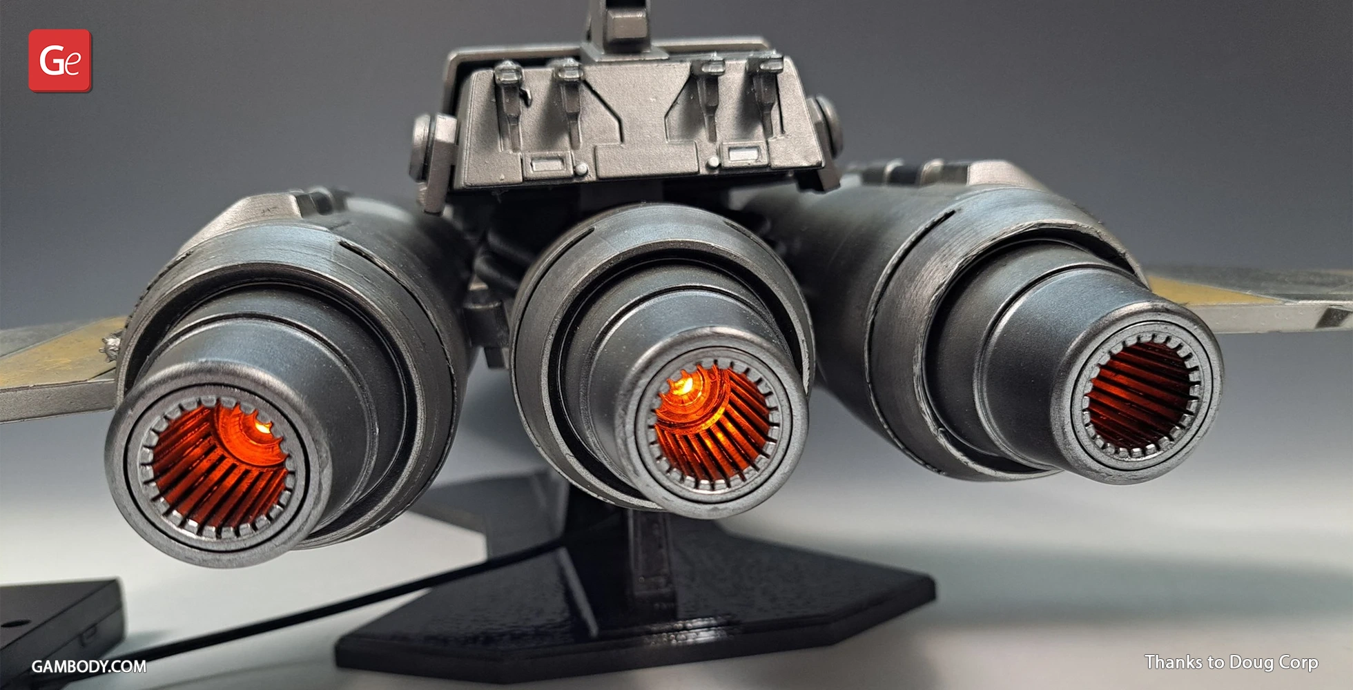 Back view of a Star Wars-inspired triple-engine space fighter model with glowing orange exhausts.
