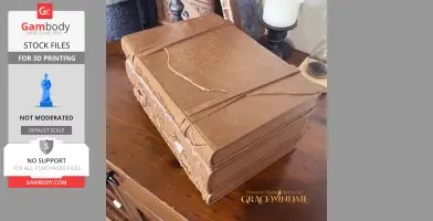 A decorative, book-shaped 3D-printed case on a wooden surface.