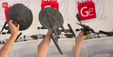 Hand holding a detailed 3D model of the Enterprise NX-01 Refit spaceship from Star Trek.