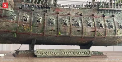 Detailed model base of the Flying Dutchman ship with intricate designs, labeled on a display stand.