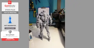 A detailed gray 3D-printed armored character model standing on a workbench.