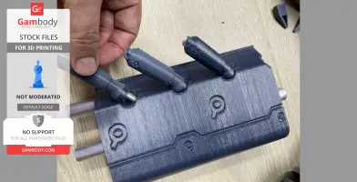 A hand holding a 3D printed part of a futuristic weapon with engraved details and a mechanical design.