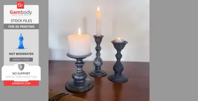 Three black candle holders of varying heights with lit candles on a wooden surface.