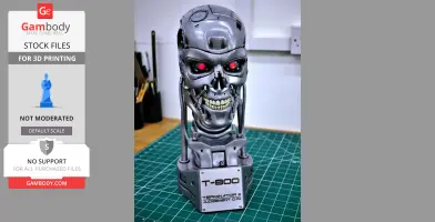 Metallic T-800 Terminator skull with red eyes on a green cutting mat, labeled base.