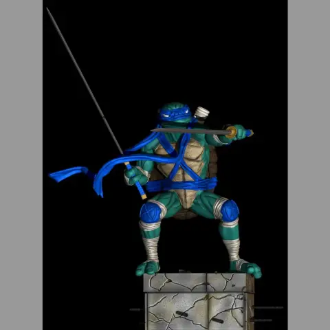 Blue-masked turtle warrior holding a katana, standing on a cracked stone pedestal.