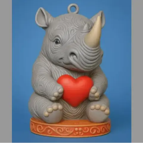 Cute rhino figurine holding a red heart, sitting on a decorated base with a loop on top.