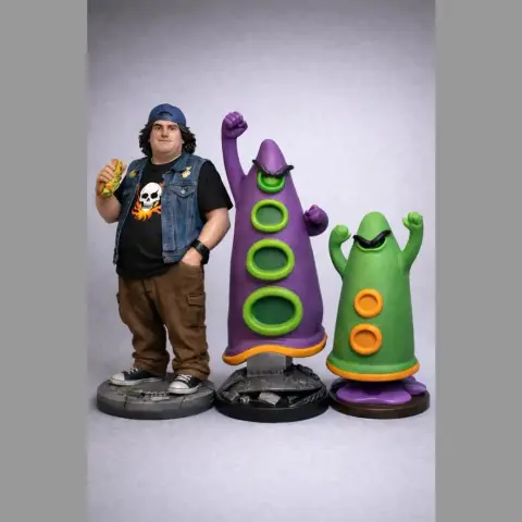 A character with a skull shirt and two colorful, cone-shaped tentacle figures on stands.