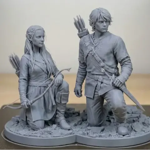 A 3D printed model of two characters with bows and arrows, standing and kneeling on a rocky base.