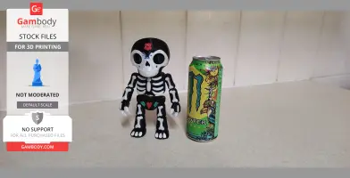 A Day of the Dead-themed skeleton puppet beside a colorful energy drink can on a countertop.