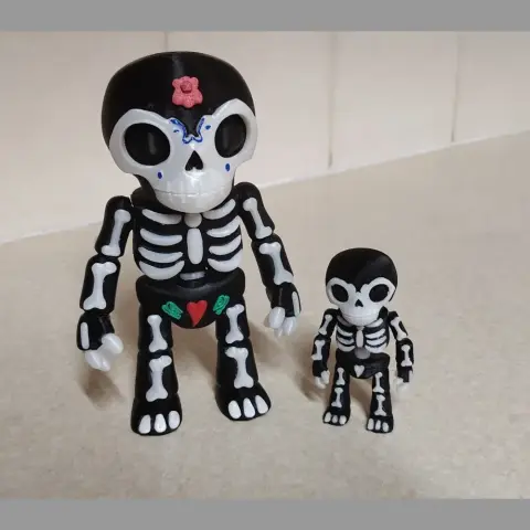 Two black-and-white skeleton figures with colorful details, inspired by Day of the Dead designs.