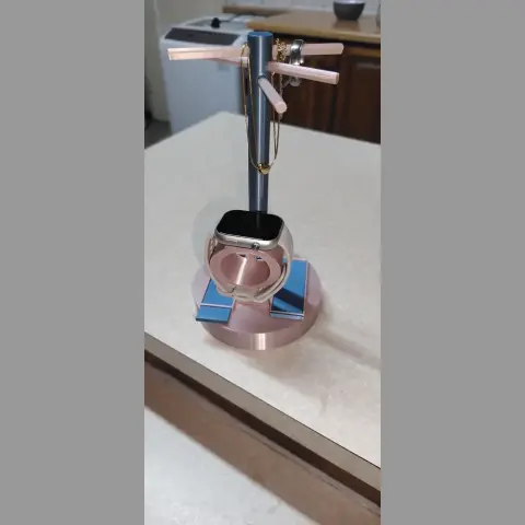 A sleek jewelry stand with a cylindrical base, arms for hanging items, and sliding compartments.