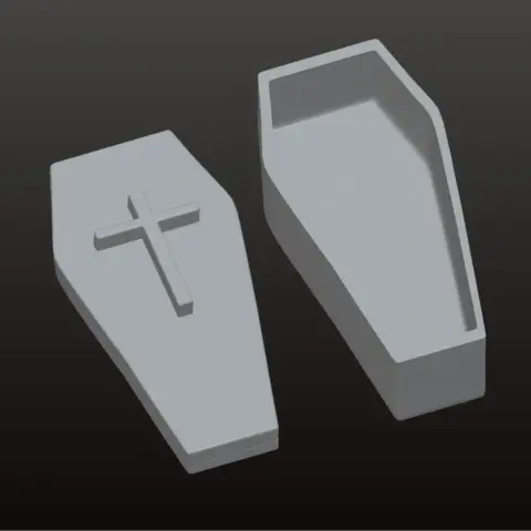 A coffin-shaped jewelry box model, with a cross on the lid, in two separate pieces.