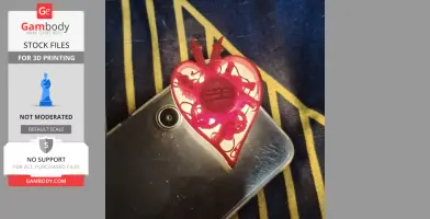 A red, mechanical heart-shaped 3D print with gears, placed on a smartphone.